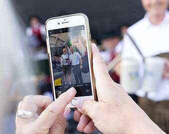 Smartphone macht Foto, im Display Menschen