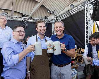 Männer mit Bierkrügen Gruppenbild